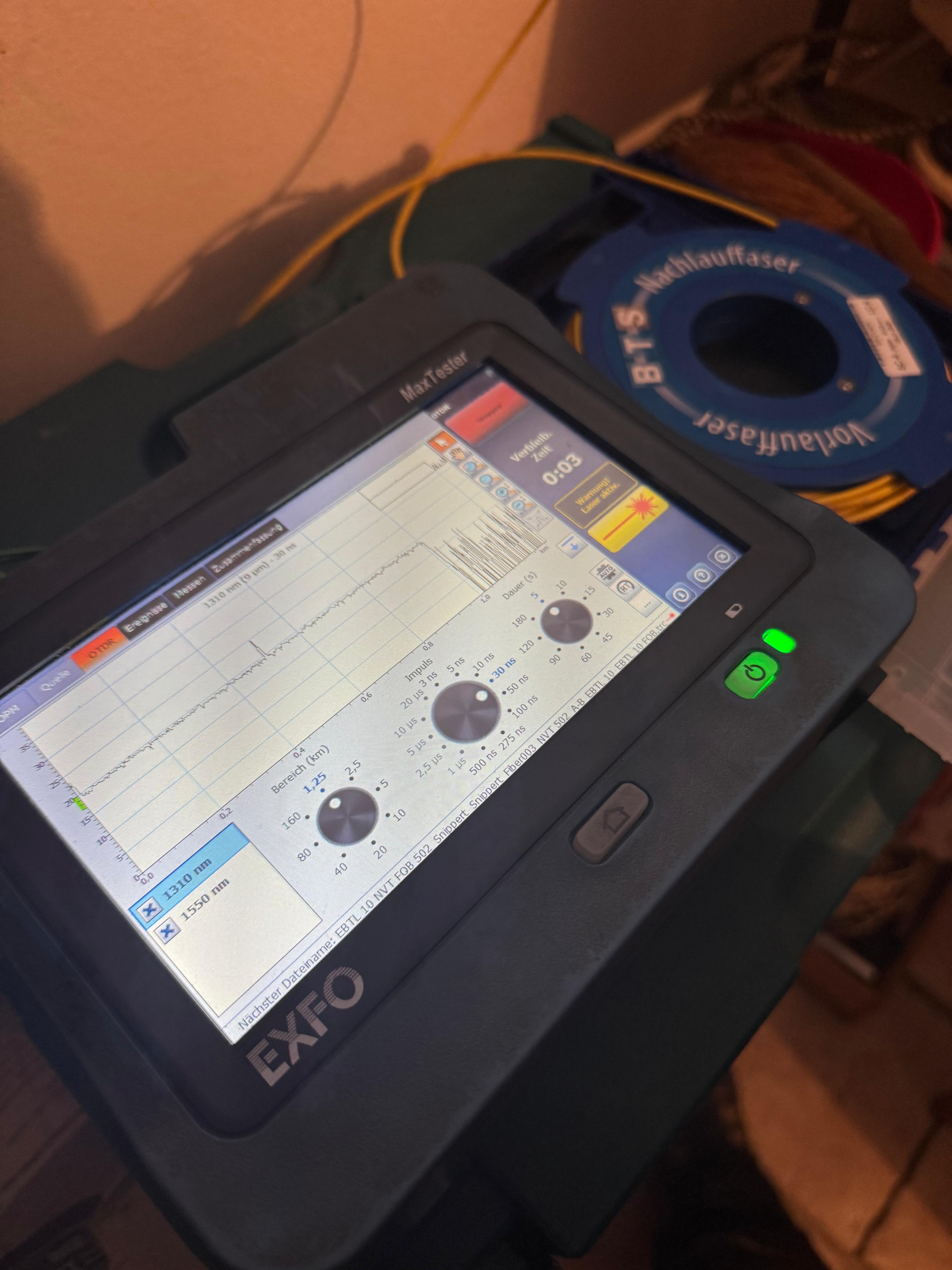 Techniker führt Messung mit OTDR-Gerät an Glasfaserkabel durch